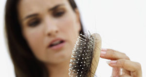 Mulher sofrendo com a queda de cabelo na menopausa