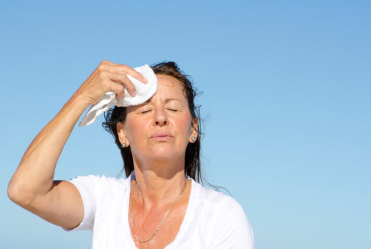 Mulher sente o calor da menopausa